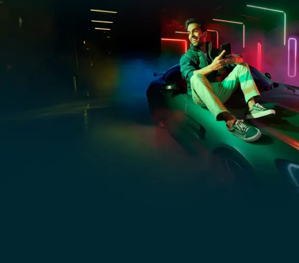 Young man using his smartphone in a car on a Salam unlimited data plan